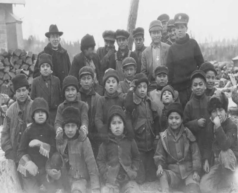 Group of people sitting and standing outside from Kamloops St. Louis School