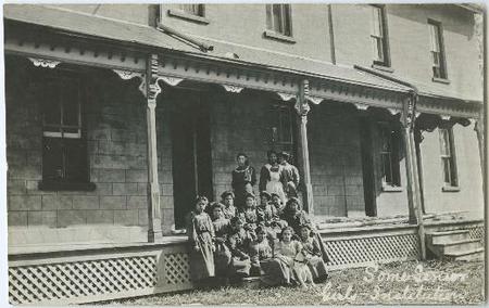 group of people sitting and standing in front of building