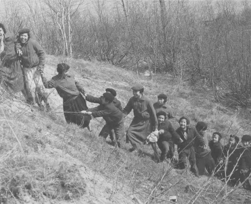 Group of people climbing hill at Amos school 