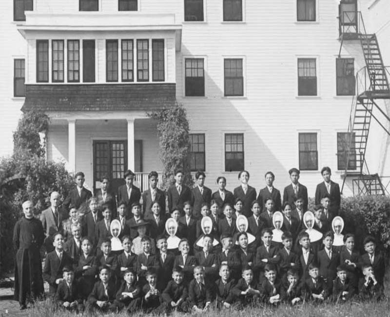 Group of students and teachers outside Thunderchild St. Henri school building