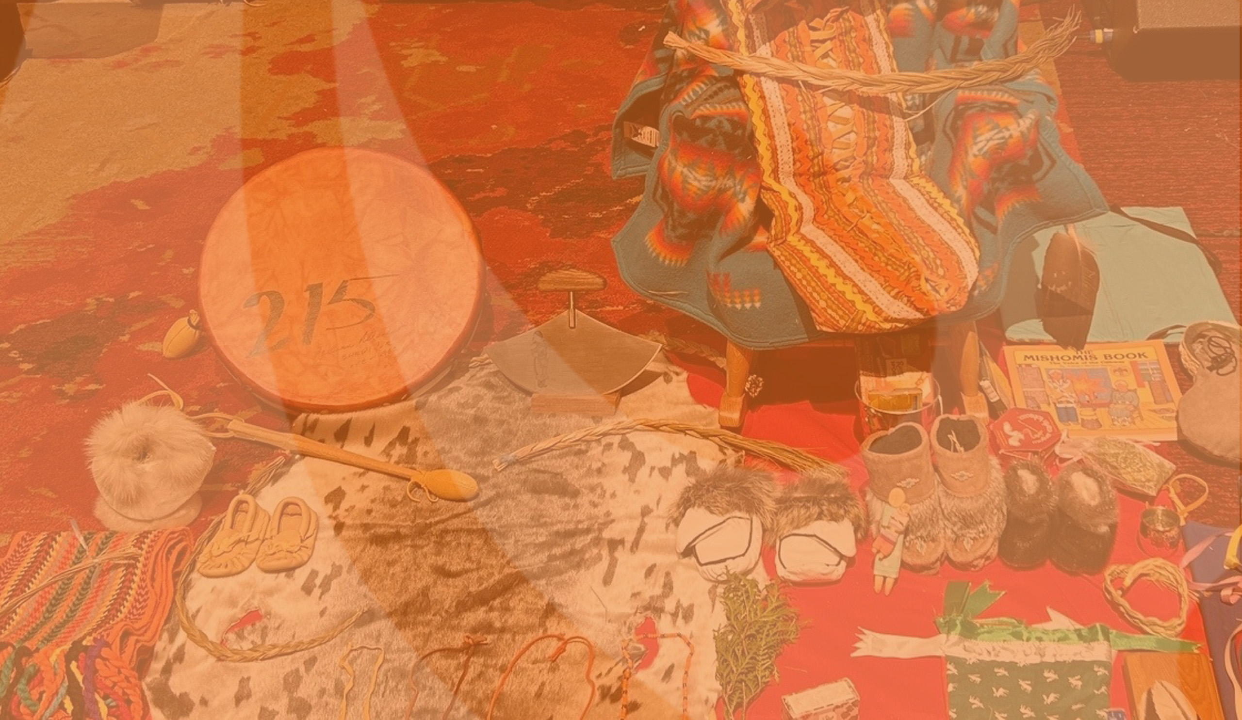 Photo collage of Indigenous children&#039;s items with an orange filter