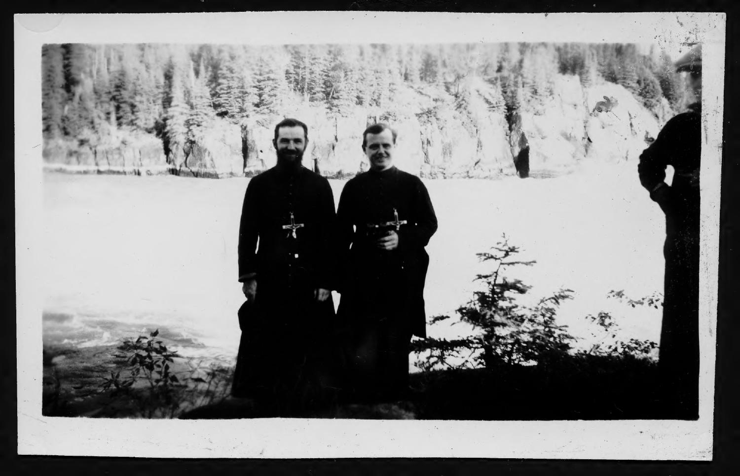 Father Rosaire Rho and Fr. Germain Lesage and a third man standing in front of White Mud falls, on Nel river.